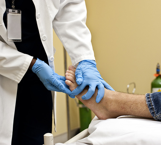 Un médecin auscule le pied d'un homme - MACSF