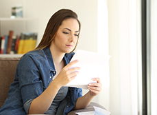 Une femme assise lit un courrier - MACSF