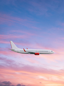 Un avion en vol dans un ciel rose et bleu - MACSF