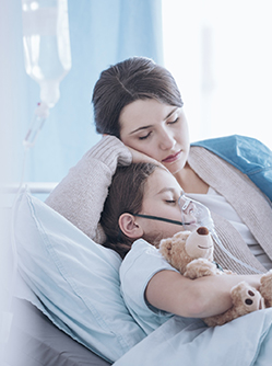 Une maman allongée à côté de son fils sur le lit de l'hôpital - MACSF