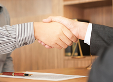 Gros plan sur une poignée de mains entre deux hommes  dans le bureau du juge - MACSF