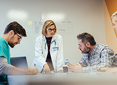 Quatre soignants discutent d'un dossier à l'hôpital - MACSF