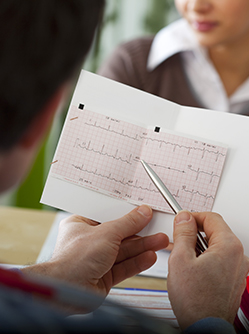 Un cardiologue observe l'ECG d'une patiente en consultation - MACSF