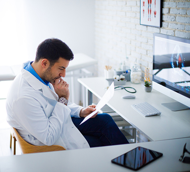 Un médecin réfléchit en lisant un document - MACSF
