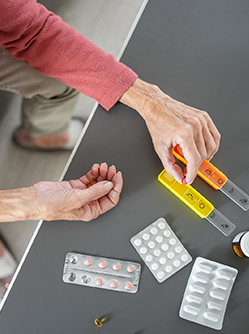 Gros plans sur les mains d'une femme âgée préparant son pilulier - MACSF