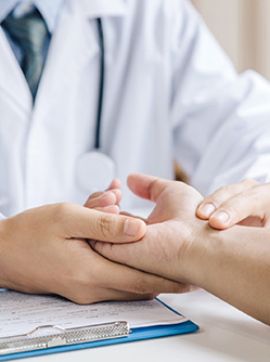 Un médecin examine le poignet de son patient - MACSF