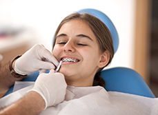 Vérification des bagues orthodontiques d'une adolescente par le chirurgien-dentiste - MACSF