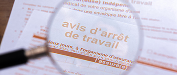 Gros plan à travers une loupe d’un formulaire officiel d’arrêt maladie de la sécurité sociale - MACSF