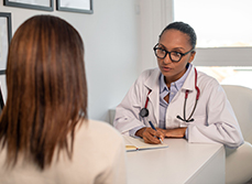 Une femme médecin face parle à une patiente assise au bureau - MACSF