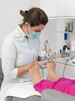 Une pédicure-podologue réalise des soins sur une patiente - MACSF