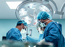 Une équipe chirurgicale vêtue de bleu penchée sur un patient - MACSF