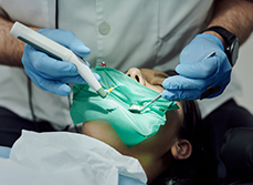 Un chirurgien-dentiste pratique des soins sur une patiente - MACSF