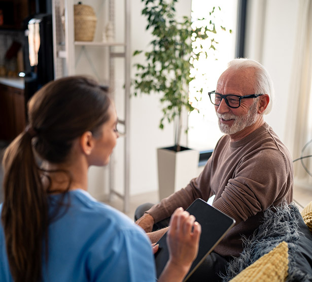 Une infirmière à domicile discute avec un patient - MACSF