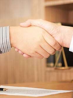 Gros plan sur une poignée de mains entre deux hommes  dans le bureau du juge - MACSF