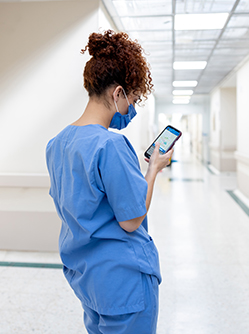 Une infirmière consultant son téléphone portable dans le couloir de l'hôpital - MACSF