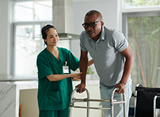 Une infirmière aide un patient avec un déambulateur - MACSF