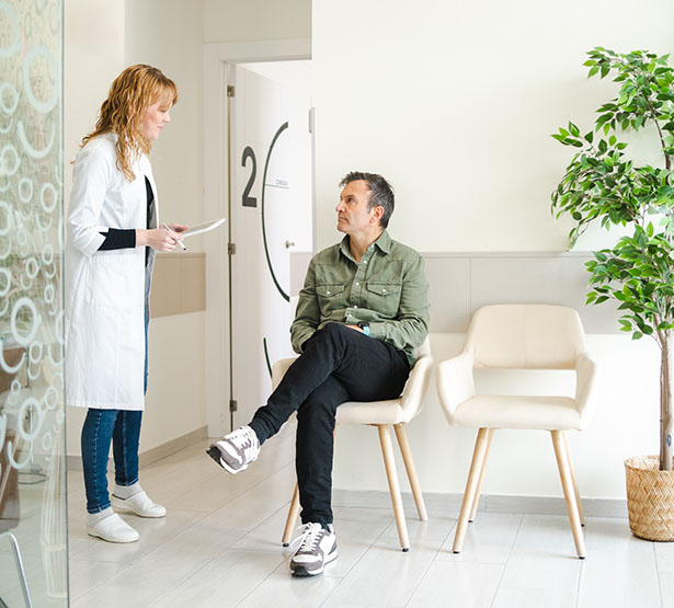 Une femme médecin s'adresse à un patient assis dans la salle d'attente du cabinet - MACSF