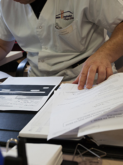 Un homme à son bureau examine des documents - MACSF