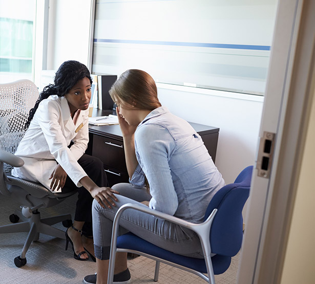 Une professionnelle de santé discute avec une patiente triste - MACSF