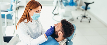 Une dentiste examine les dents des son patient - MACSF