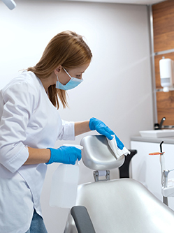 Une chirurgien-dentiste nettoie le fauteuil du cabinet - MACSF