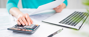 Une main de femme utilisant une calculatrice, en train de saisir ou vérifier des chiffres - MACSF