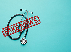 Un stéthoscope posé sur un fond bleu avec la mention fake news - MACSF