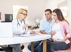 Une femme enceinte et son mari en consultation chez le médecin - MACSF